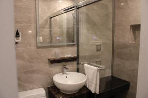 a bathroom with a sink and a shower at Olux Hotel-Motel-Suites in Laval