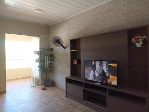 a living room with a flat screen tv on a wall at Duplex Praia dourada in Maragogi