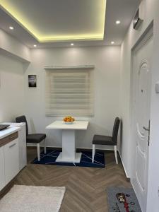 a kitchen with a white table and two chairs at Surčin Centar apartment in Surčin