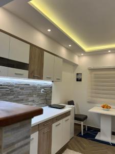 a kitchen with white cabinets and a counter top at Surčin Centar apartment in Surčin