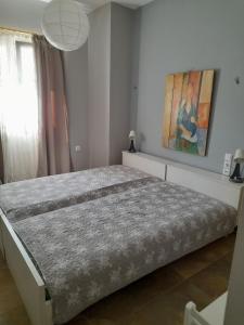 a large bed in a bedroom with a painting on the wall at manesi stone built studio in Manésion