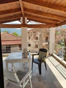 een patio met een tafel en stoelen bij manesi stone built studio in Manésion