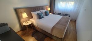 una camera da letto con un grande letto bianco con cuscini blu di Zmaj 94 a Bečej