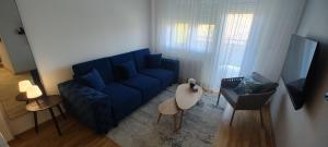 un soggiorno con un divano blu e un tavolo di Zmaj 94 a Bečej
