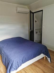 a bedroom with a bed with a blue blanket at Chopin in Les Haies
