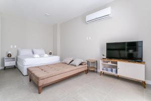 a living room with a bed and a tv at Wi-Fi 250MB | Sea View | Pool #CA61 in Florianópolis