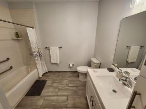 a bathroom with a tub and a toilet and a sink at Astonishing 2BR Apt Mins to NYC in Jersey City