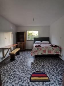 a bedroom with a bed and a table and a bench at Refugio Kiñeco in Conguillío