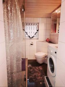 ein Badezimmer mit einer Waschmaschine und einer Waschmaschine in der Unterkunft Single room for you in Hünxe