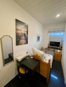 a room with a desk and a bed and a mirror at Single room for you in Hünxe