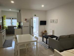 a kitchen and living room with a table and a couch at Casa de Casarelhos - Estúdio Piso 0 ou AL Piso 1 - "Gerês" in Geres
