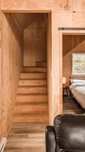 Cette chambre est dotée de murs en bois et d'un escalier avec un lit. dans l'établissement Le Crustacé, à Nouvelle