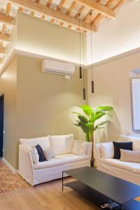 a living room with two white couches and a table at Precioso ático con mucho encanto in Sant Feliu de Guixols