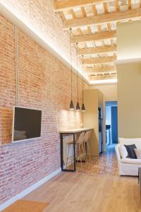 a brick wall in a living room with a tv at Precioso ático con mucho encanto in Sant Feliu de Guixols