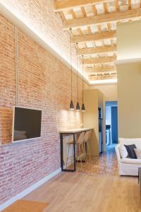 a brick wall in a living room with a tv at Precioso ático con mucho encanto in Sant Feliu de Guíxols