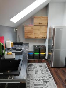 a kitchen with a stainless steel refrigerator and some trash cans at Pokoje Gościnne u Joli in Szczyrk