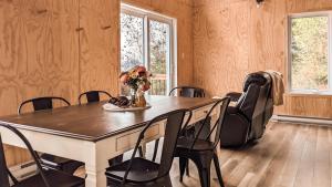 a dining room table with chairs and a vase of flowers at Le Crustacé 2 a 4 personnes in Nouvelle
