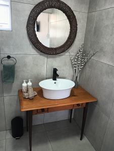 La salle de bains est pourvue d'un lavabo et d'un miroir sur une table. dans l'établissement Bly 'n Bietjie Ceres, à Ceres
