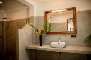 a bathroom with a sink and a mirror at Woradi Solitude Bungalow in Talpe