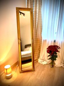 uno specchio in una stanza con un letto e un vaso di fiori di Art Luxury Apartment - central, metro to airport a Sofia