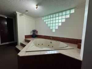 a bath tub in a bathroom with a window at Suites & Hotel Gonzalez Suarez in Quito