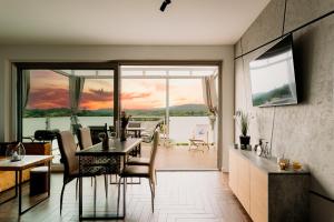 a dining room and living room with a view of the ocean at Domy na Roztoczu Aleja Lipowa B,G,J,K Sauna Jacuzzi Kajaki in Zwierzyniec