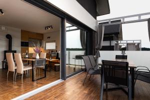 a dining room and living room with sliding glass doors at Domy na Roztoczu Aleja Lipowa B,G,J,K Sauna Jacuzzi Kajaki in Zwierzyniec