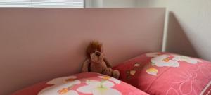 a stuffed teddy bear sitting on top of two pillows at Ferienwohnung "Erika" Rees am Niederrhein in Rees