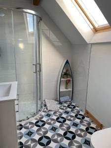 a bathroom with a shower and a black and white tile floor at Rossnowlagh Beach House in Donegal