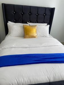Cama con manta y almohadas azules y blancas en Luxurious furnished home thika road en Nairobi