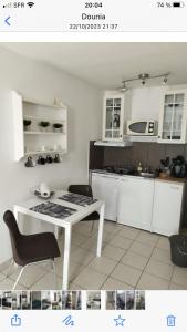 een keuken met een witte tafel en een wit aanrecht bij studio au vieux port in Marseille