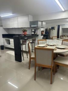 eine Küche mit einem Tisch und Stühlen mit Weingläsern darauf in der Unterkunft Apto 16 lindo e confortável in Montes Claros