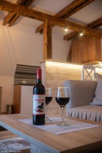 uma garrafa de vinho e dois copos numa mesa em Zlatar Eyes em Nova Varos