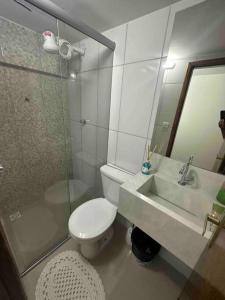 ein Bad mit einem WC, einem Waschbecken und einer Dusche in der Unterkunft Apto 16 lindo e confortável in Montes Claros