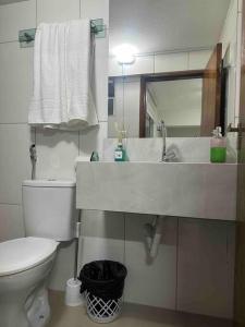 a bathroom with a sink and a toilet and a mirror at Apto 16 lindo e confortável in Montes Claros