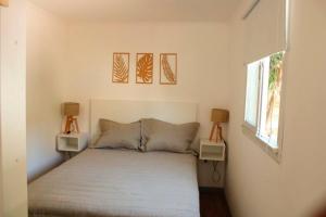 a bedroom with a bed and two lamps on the wall at CABAÑA MOAI in Mar del Plata