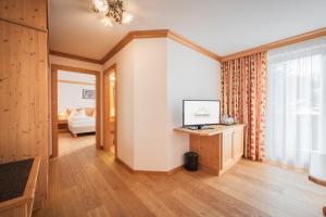 a living room with a large window and a bedroom at Biohotel Leutascherhof in Leutasch