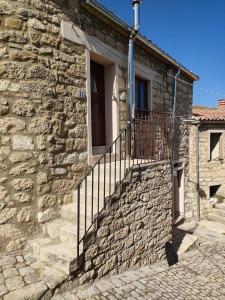 a stone house with a staircase and a window at Borgo i Stritti in Petralia Soprana