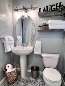 een badkamer met een wastafel, een toilet en een spiegel bij Beautiful Colorado Home, Centrally Located! Great Yard! in Wheat Ridge