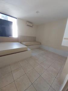 a white room with a window and a tiled floor at Flats Temporada & Mensal in Aracaju