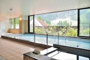 a large swimming pool in a building with a large window at Tateyama Kokusai Hotel in Toyama