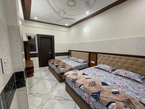 a bedroom with two beds and a ceiling at Gayatri Dham in Vrindāvan