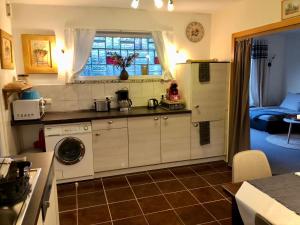a kitchen with a washer and a refrigerator and a window at Haus Sonnenschein in Bispingen