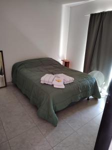 a bedroom with a bed with two towels on it at Alquiler Temporario ZOE 1 Gral Roca - Rio Negro in General Roca
