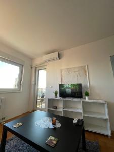 ベオグラードにあるLV Apartmentsのテーブルとテレビのあるリビングルーム