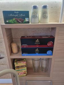 a wooden shelf with some food and cups on it at Apartament Ultracentral Suceava in Suceava +4 photos