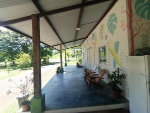 une terrasse couverte d'un bâtiment avec des chaises et des plantes dans l'établissement Tortuga Hostal, à Pedregal