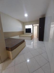a large room with two beds and a television at Flats Temporada & Mensal in Aracaju