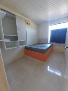 a small room with a bed and a window at Flats Temporada & Mensal in Aracaju