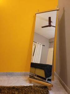 a mirror in a room with a yellow wall at Pearl - Sunflower Skyline in Bangalore